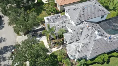 Roofer removing old shingles during a roof replacement in Bradenton.