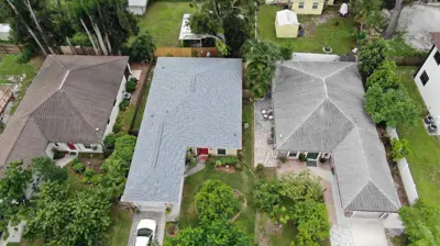 Aerial view of three Florida homes showcasing well-maintained shingle roofs by Mighty Dog SWFL.