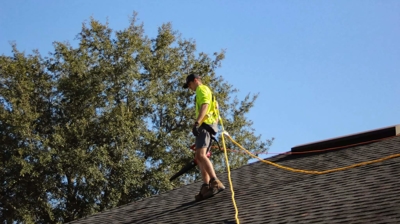 man holding wire on a roof