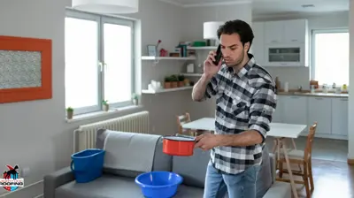 Man with pot standing in kitchen catching water leaking from roof
