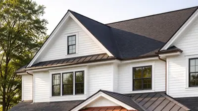 White colonial home with dark charcoal roof and copper accents in Rhode Island showcasing modern roof design trends.