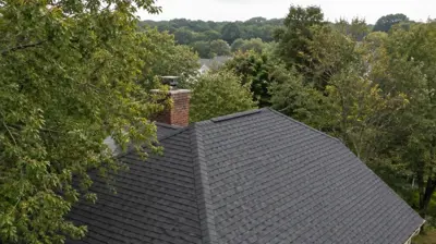 Drone view of a Cranston, RI roof replacement under mature tree canopy