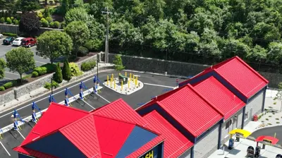 New construction commercial building in Coventry, Rhode Island with a red standing seam metal roof and dark blue siding.