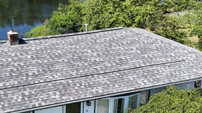 New hip roof replacement with IKO Dynasty Class 3 shingles and custom chimney flashing in North Providence, RI by Mighty Dog Roofing of Rhode Island.