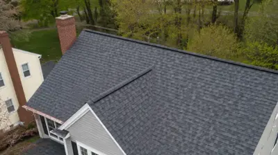 Drone view of a new architectural shingle roof with copper drip edge on a suburban home in Providence County, Rhode Island.