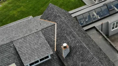 Aerial view of a Rhode Island home with premium synthetic cedar shake roofing and realistic wood-grain texture