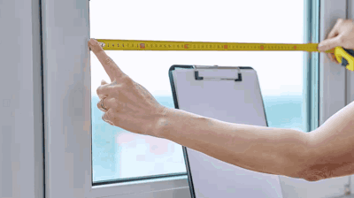 Window contractor measuring a window frame
