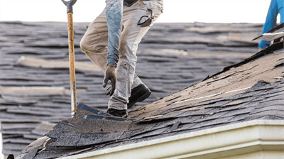 Roofer inspecting roof for wind damage