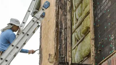 Siding contractor repairing wood rot