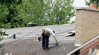 Licensed roofing contractor installing new shingles