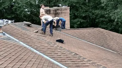 Roofer installing asphalt shingles