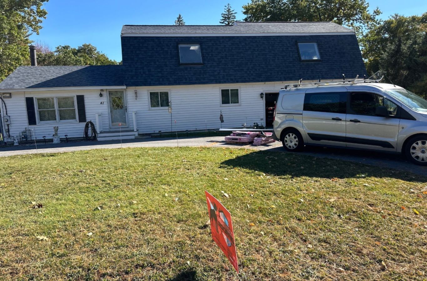 A Mighty Dog Roofing team measuring and cutting gutters on-site in Belmont, MA to create a perfect custom fit for lasting performance.