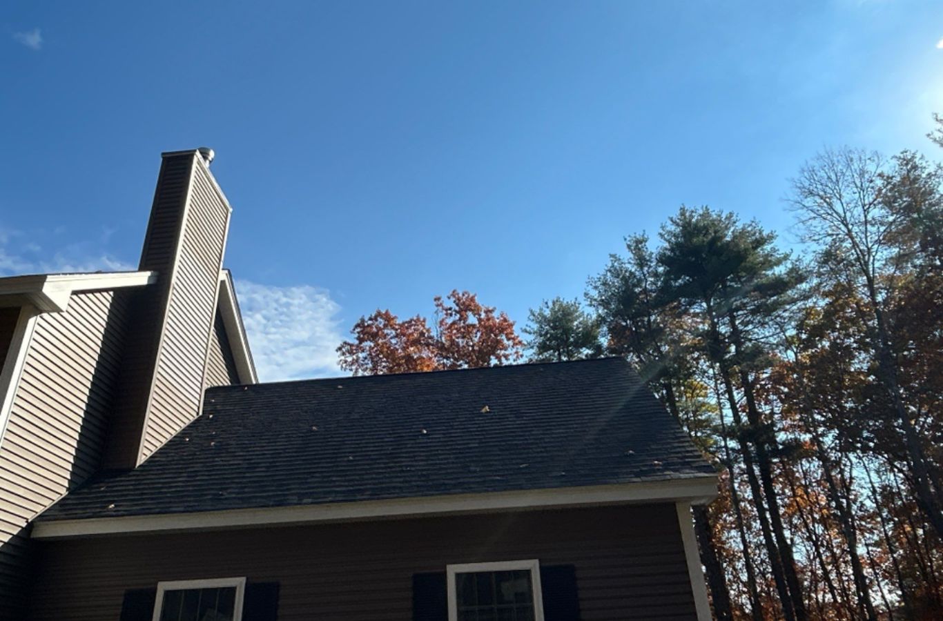 A Mighty Dog Roofing team preparing gutter sections on-site in Lexington, MA for custom fitting and smooth water drainage.