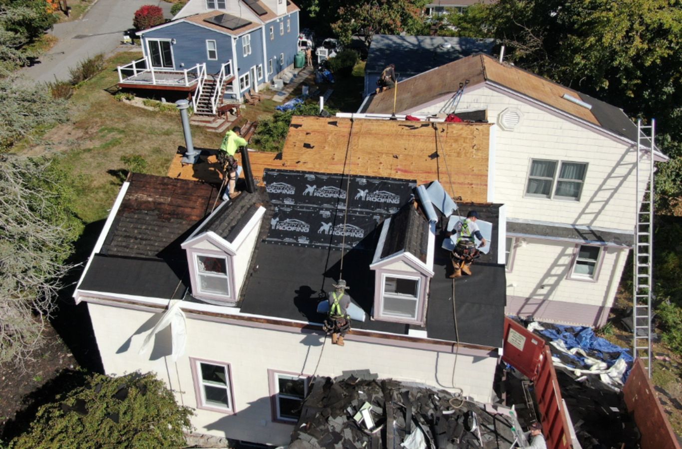 A Mighty Dog Roofing of Greater Middlesex County crew working on roof repair in Waltham, MA, showcasing attention to detail and care.