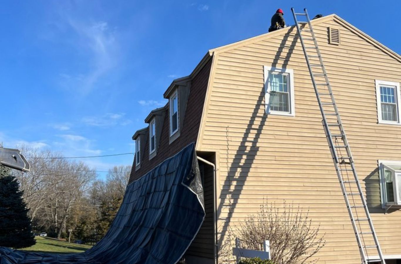 A Mighty Dog Roofing of Greater Middlesex County crew working on roof repairs in Winchester, MA, showcasing expert care.