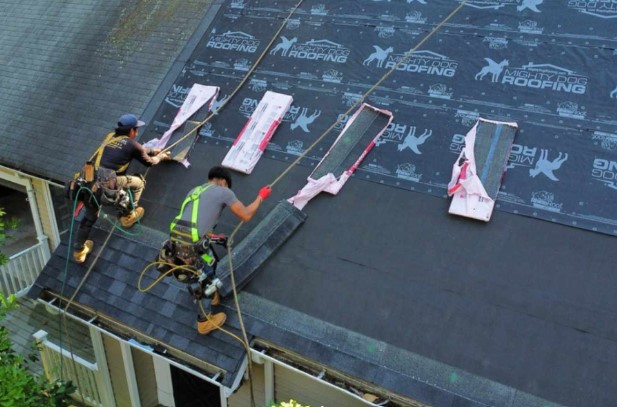 Local roofing contractor securing shingles on a Carlisle, MA roof. Roofing Company near me.