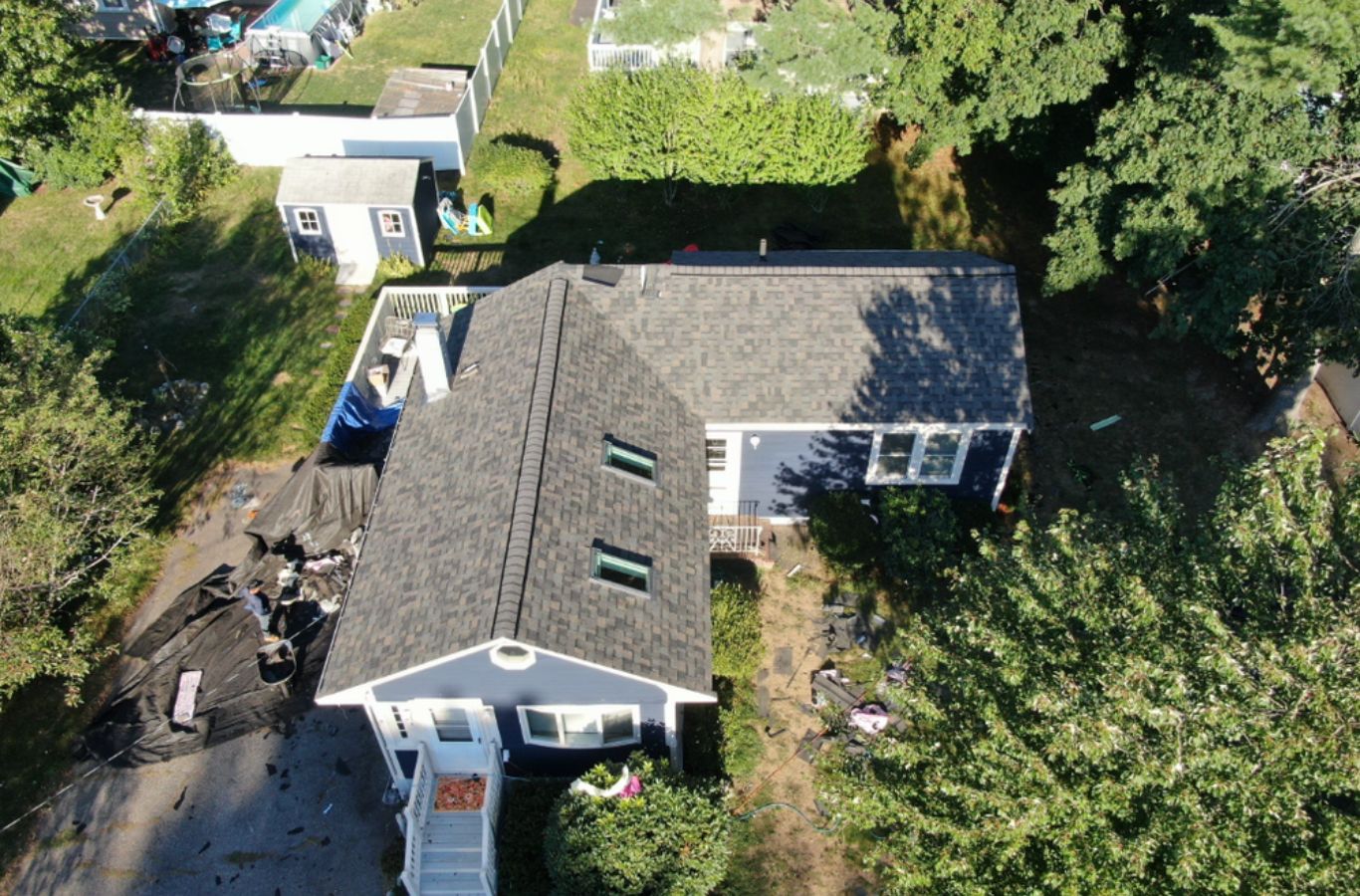 A Mighty Dog Roofing professional installing gutters on a home in Ayer, MA, ensuring proper drainage and long-lasting protection.