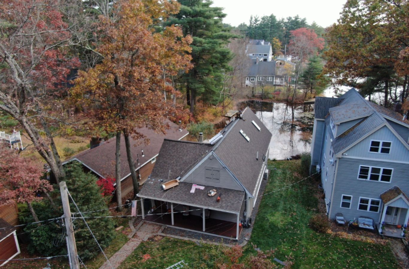 A Mighty Dog Roofing team member measuring gutters in Tyngsborough, MA to ensure a clean install that protects the home from water damage.