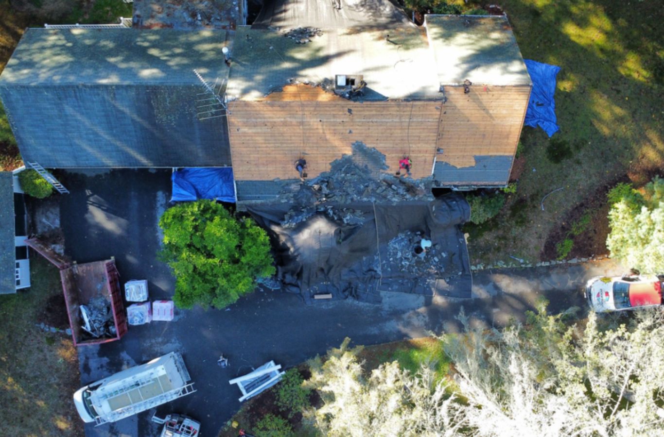 A Mighty Dog Roofing of Greater Middlesex County technician repairing a rooftop in Bedford, MA, ensuring top-tier and reliable roof repair service.