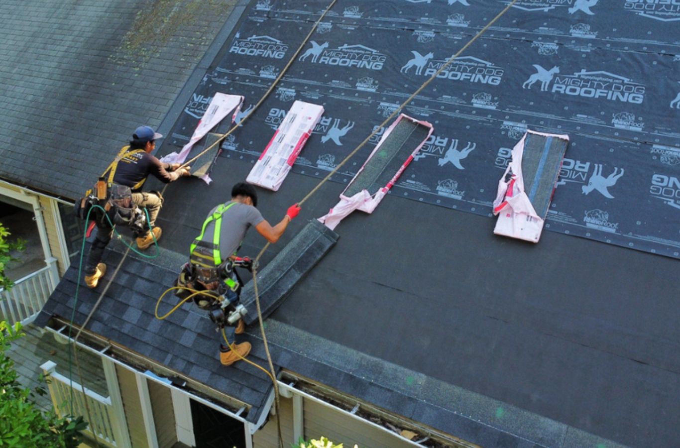 A Mighty Dog Roofing of Greater Middlesex County technician repairing rooftop shingles in Chelmsford, MA, ensuring clean and durable results.