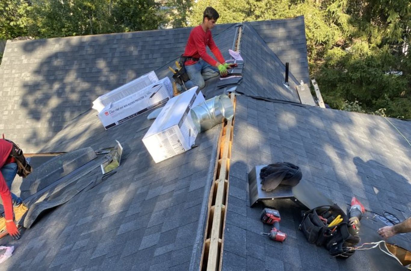A Mighty Dog Roofing of Greater Middlesex County technician repairing shingles on a residential roof in Lincoln, MA, ensuring quality results.