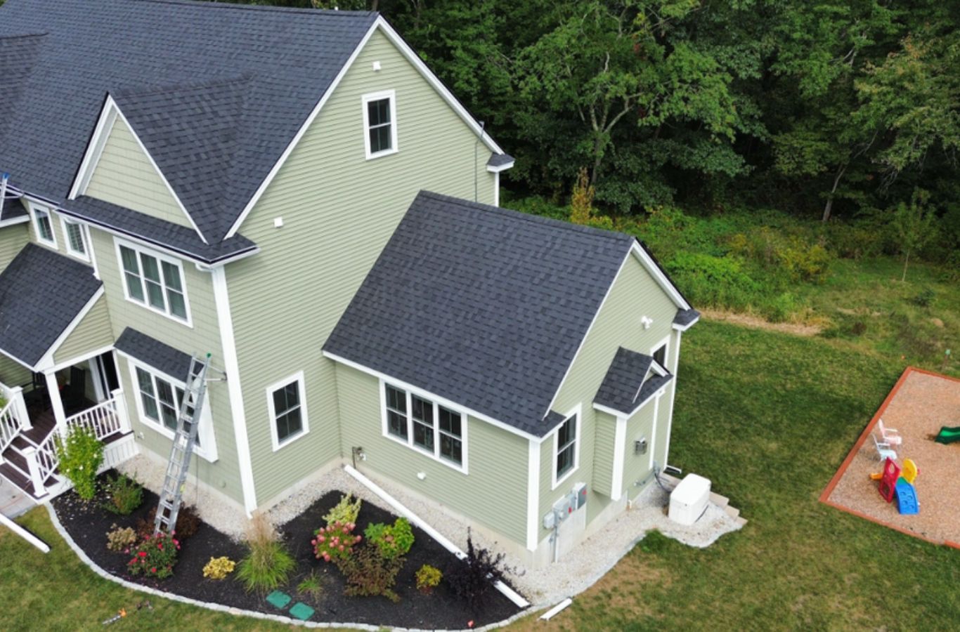 A Mighty Dog Roofing of Greater Middlesex County crew member installing siding in Dunstable, MA using high-performance materials and professional tools.