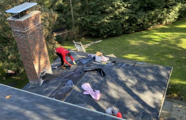 Roofing contractor finishing a new roof installation in Waltham, MA. Roofing Company near me.