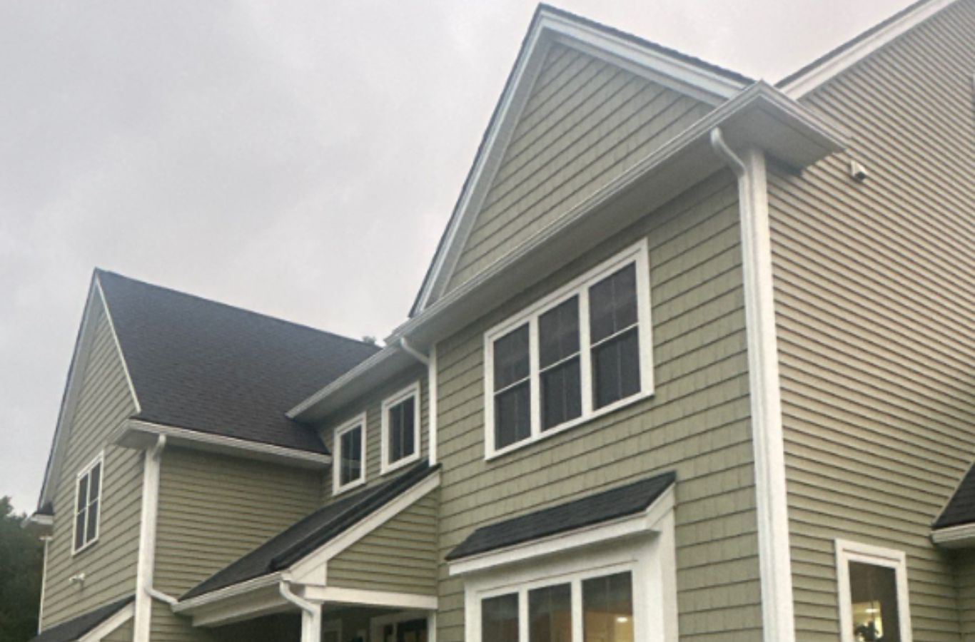 An expert from Mighty Dog Roofing repairing gutter seams on a Dunstable, MA home, showcasing quality installation and local service. Gutter Company near me.