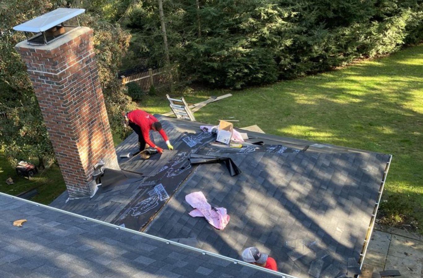 A Mighty Dog Roofing of Greater Middlesex County expert inspecting a rooftop in Burlington, MA, demonstrating professional repair quality. Roof Repair near me.