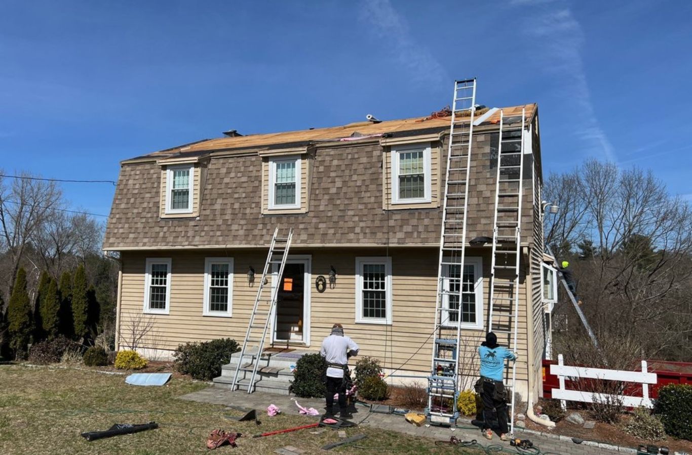 A Mighty Dog Roofing of Greater Middlesex County specialist inspecting roof shingles in Lexington, MA, ensuring expert-quality repair. Roof Repair near me.