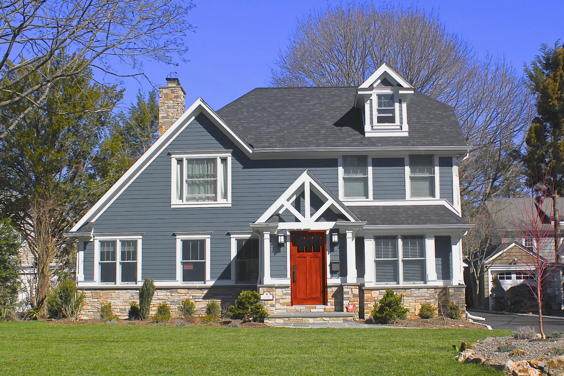evening blue siding on a home with a red door