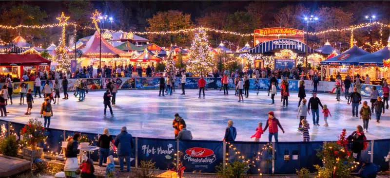 Families ice skating at Bergen County Winter Wonderland in Paramus, New Jersey during a festive holiday event at Van Saun County Park.
