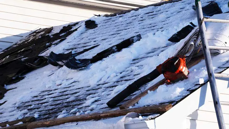 Winter roof damage caused by snow and ice showing exposed roofing materials on a Bergen County home