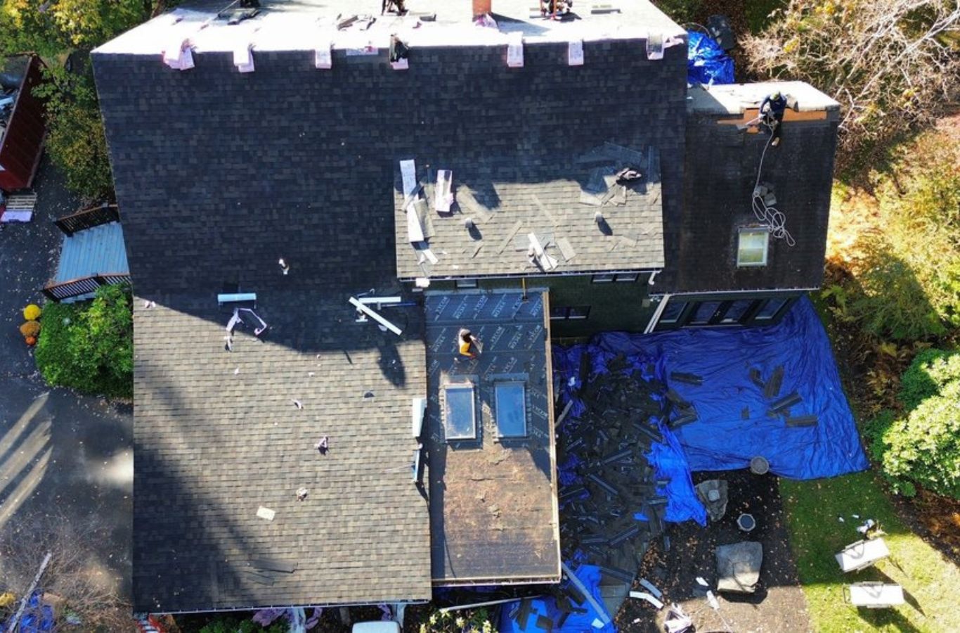 Roofing contractor from Mighty Dog Roofing working on a residential property in Lincoln, MA, ensuring a durable and precise roof installation.