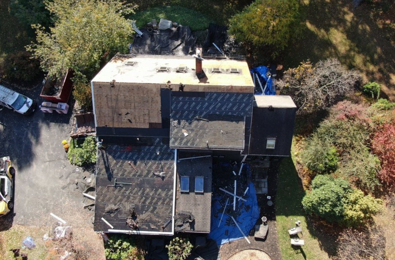 Roofing specialists from Mighty Dog Roofing applying finishing layers on a home in Lincoln, MA, roofing company near me.