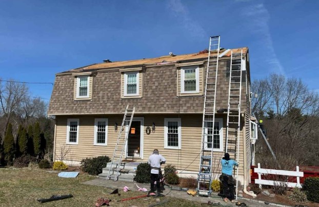 Roofing specialist from Mighty Dog Roofing working on a Wilmington, MA rooftop. Roofing Company near me.