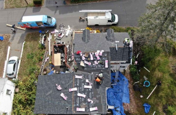 Roofer from Mighty Dog Roofing installing shingles on a Maynard, MA home.
