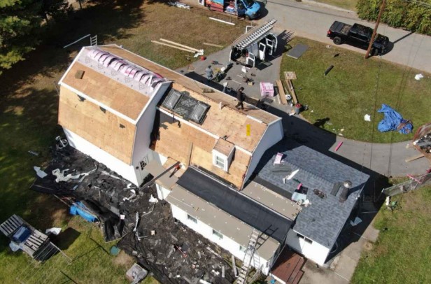Roofing expert working on a residential property in Stow, MA to provide professional-grade roofing service.
