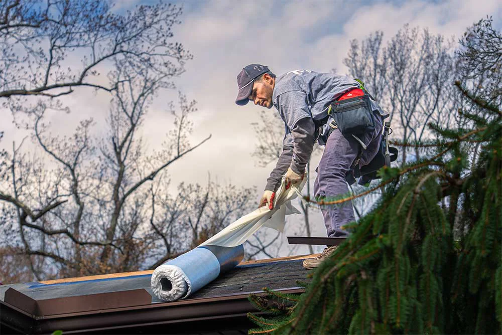Professional roofing contractor installing roofing underlayment on a residential roof in Sewell, New Jersey