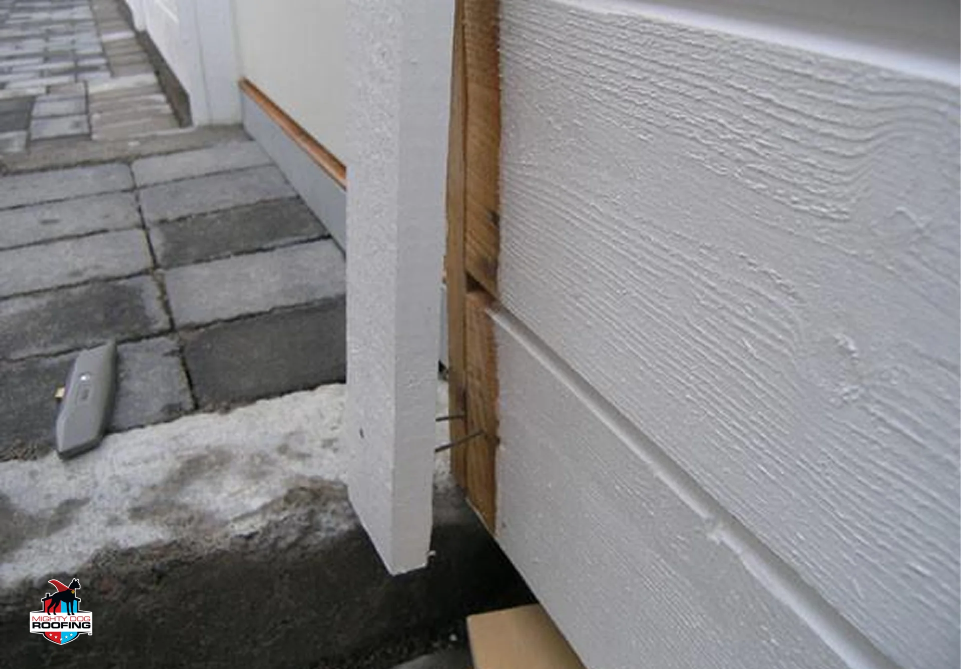 Gap between corner trim and siding near the foundation exposing the wall behind