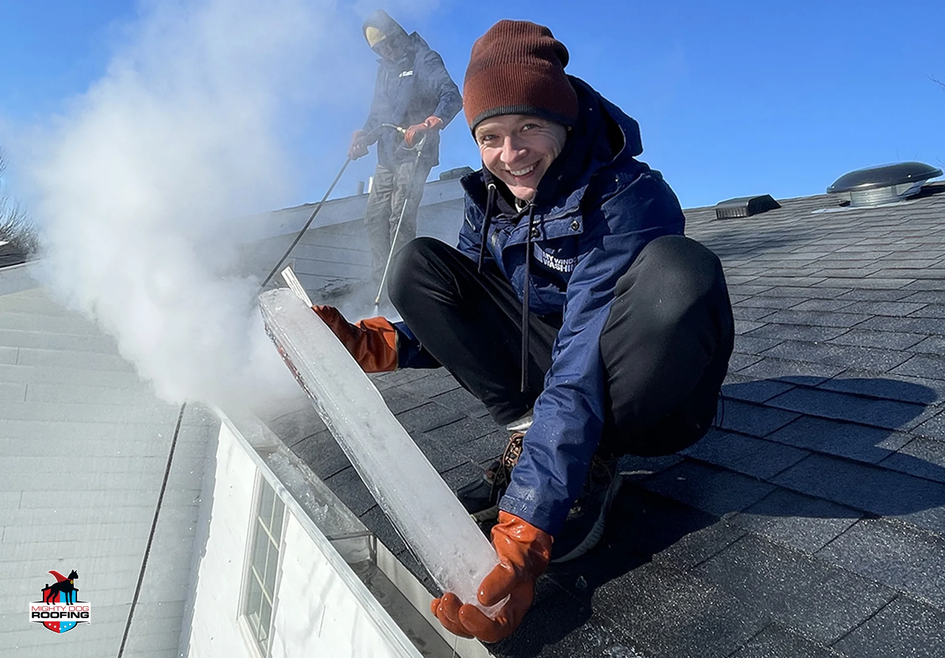 Gutter contractor removing a large ice block from a roof gutter