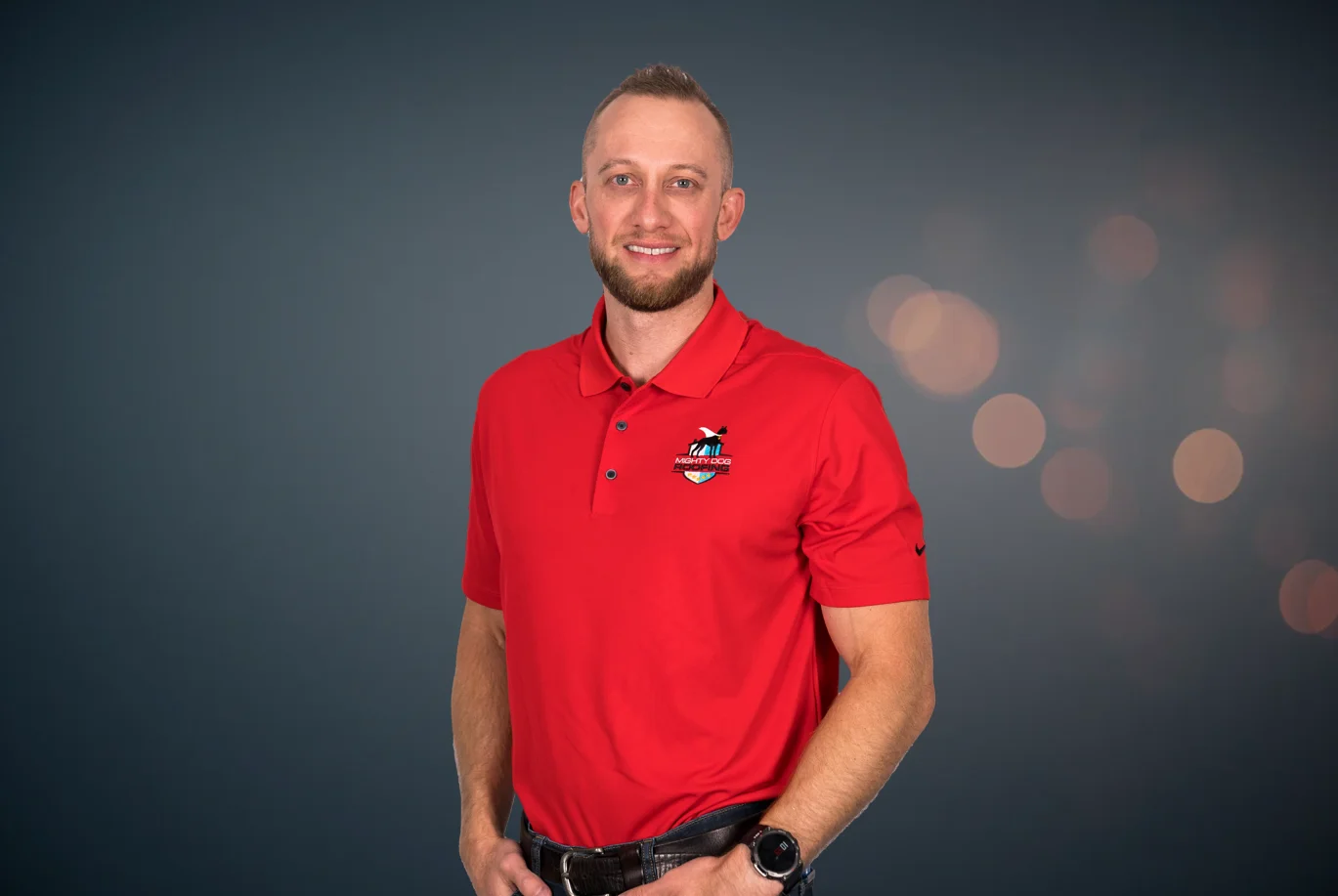 Josh Stewart, owner of Mighty Dog Roofing of Bentonville, smiling and wearing a Mighty Dog Roofing polo.
